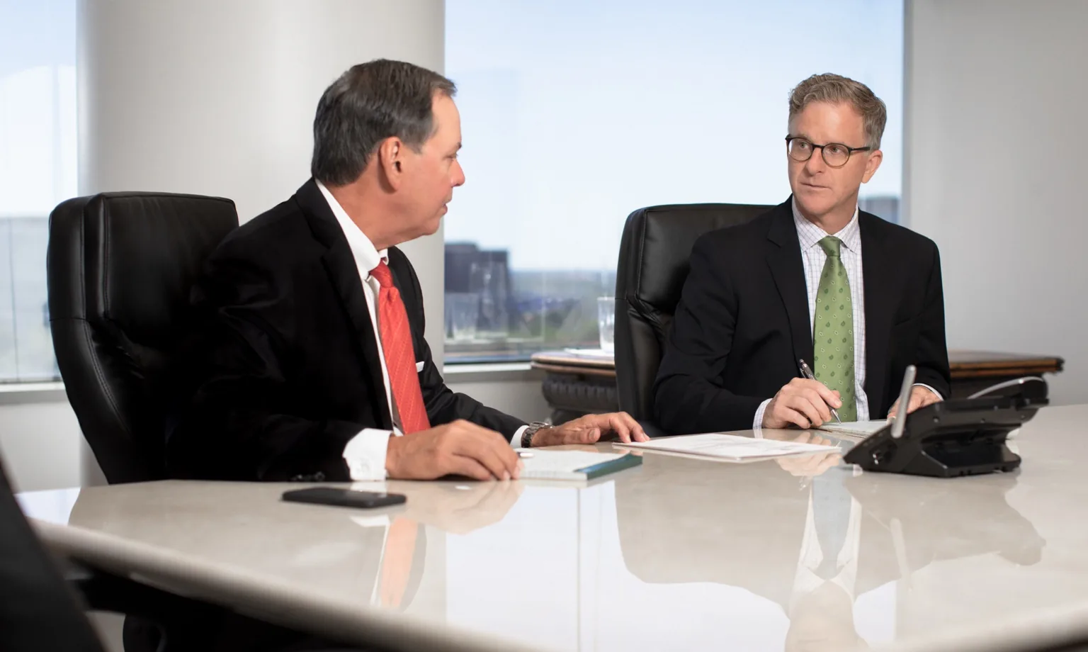 Attorneys Mitch Toups and Greg Evans working together in a conference room