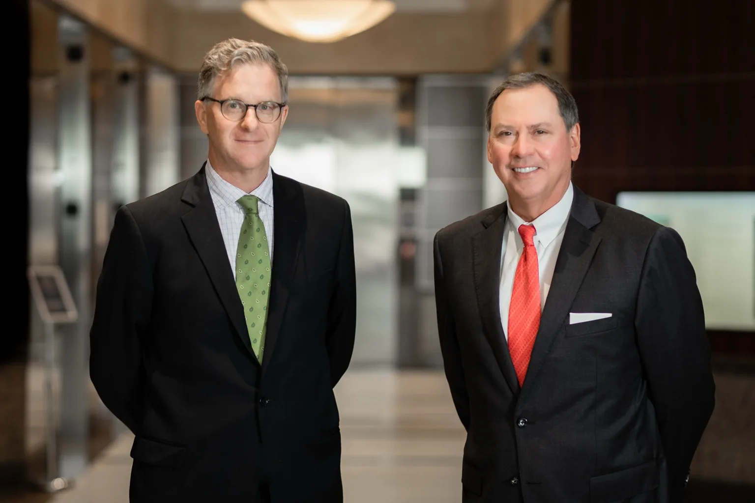 Attorneys Greg Evans and Mitch Toups standing together in an office lobby